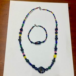Handmade beaded jewelry set in multicolor and black. Necklace and bracelet.